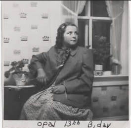 Black-and-white family photograph of Opal as a young girl seated beside a window on her 13th birthday.